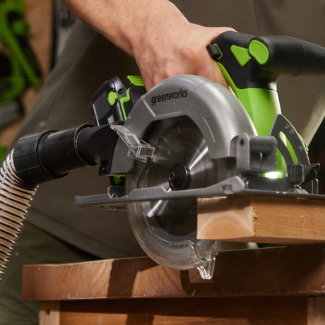 Circular saw in use with a person's hand holding it, set against a workshop background.